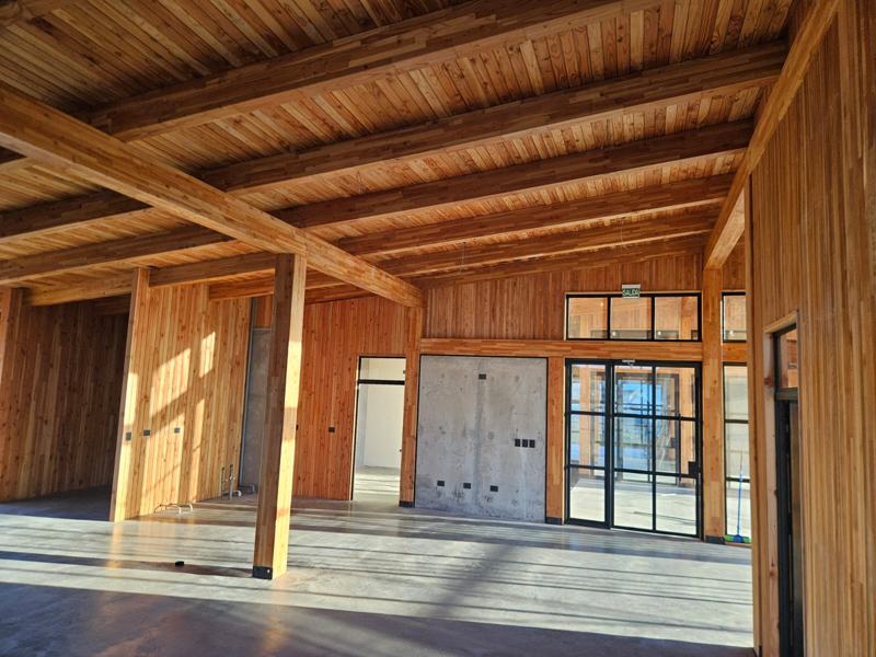 Interior de una de las alas: planta libre con vigas de madera y ventanales