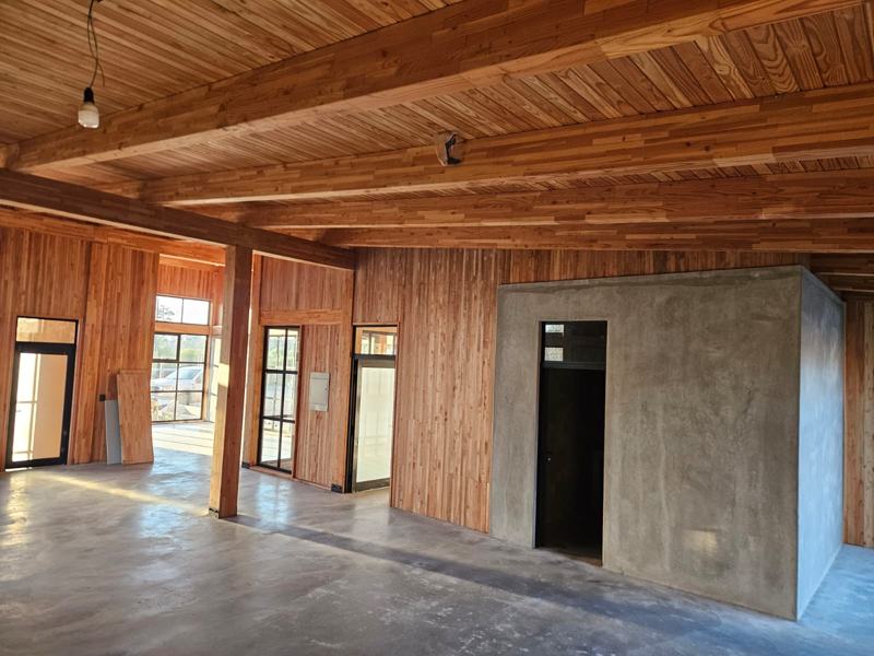 Interior de la otra ala: espacio abierto con núcleo de hormigón y estructura de madera